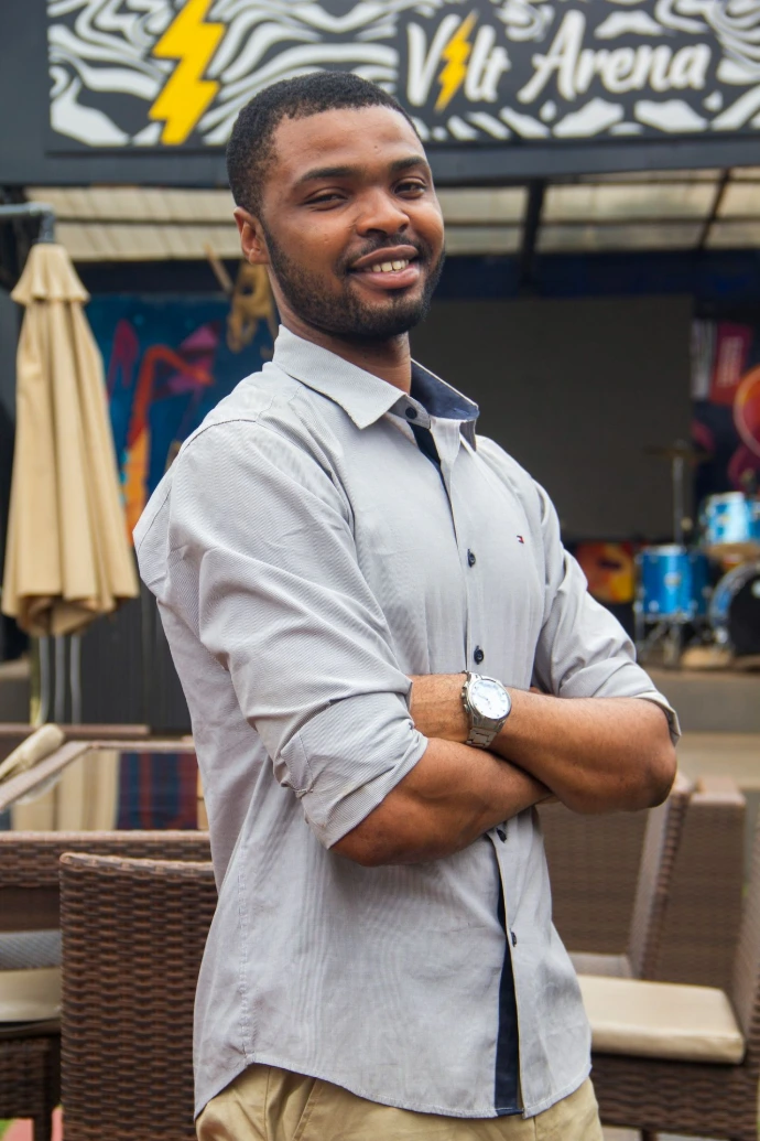 A man standing in front of a store with his arms crossed